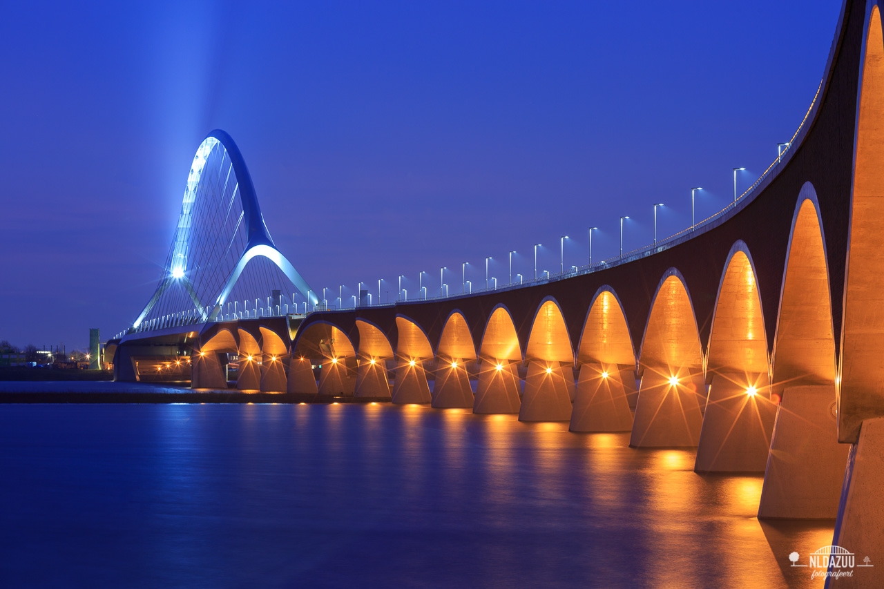 Nijmeegse Waalbrug de Oversteek in het blauwe uur met Hoogwater